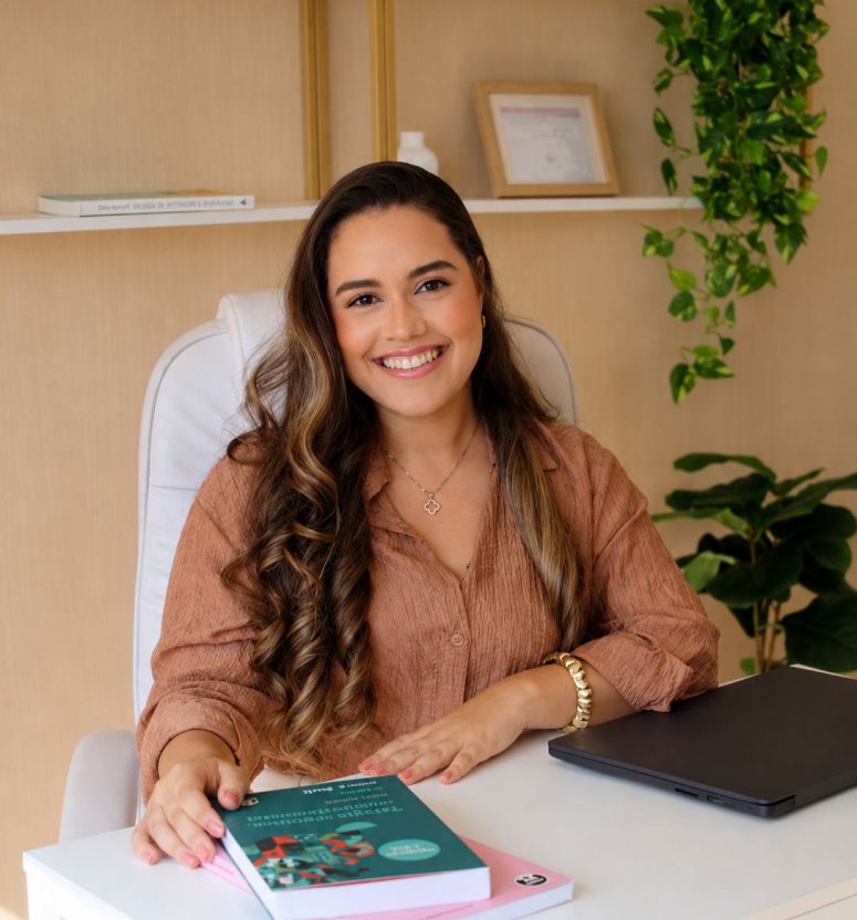 Psicóloga Camila Andrade sorrindo em seu consultório